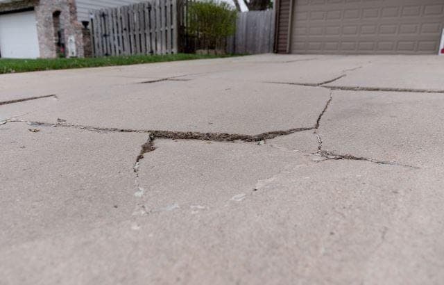Snow-covered driveway with visible salt residue near sealed concrete edge in a Southwestern Ontario winter