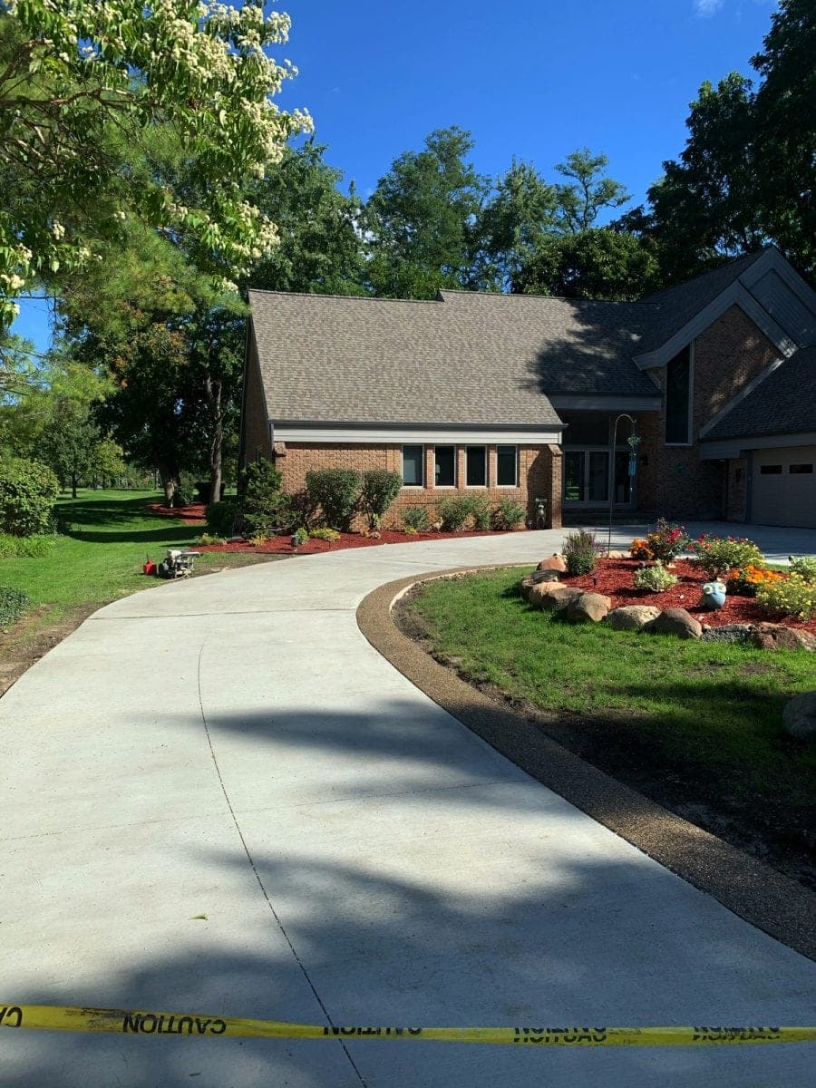 Curved broom finish concrete driveway with landscaping