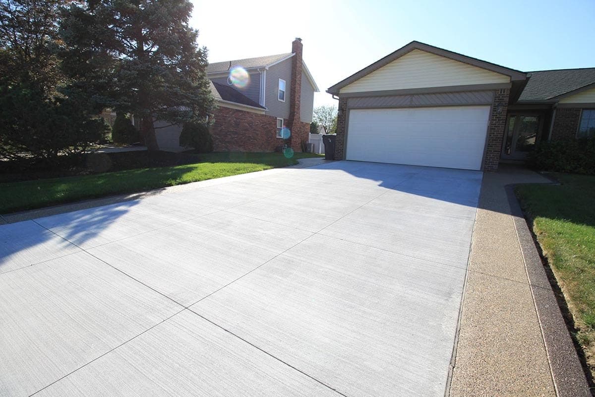 Sealed exposed aggregate driveway with stones enhanced and water beading on the surface