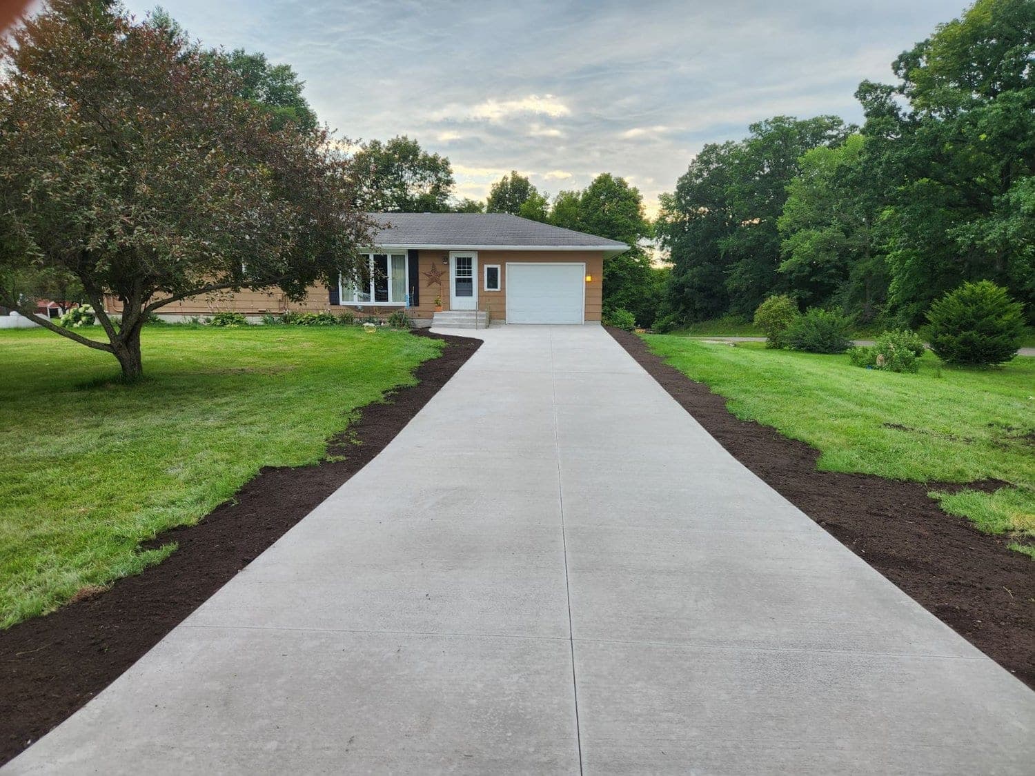 Long broom finish concrete driveway at a country home