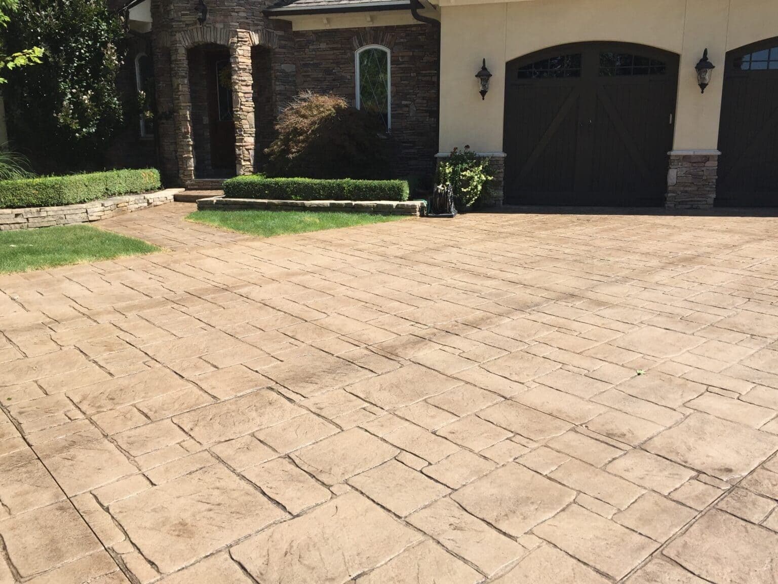 A freshly sealed concrete driveway with caution tape marking the drying period before vehicle traffic resumes