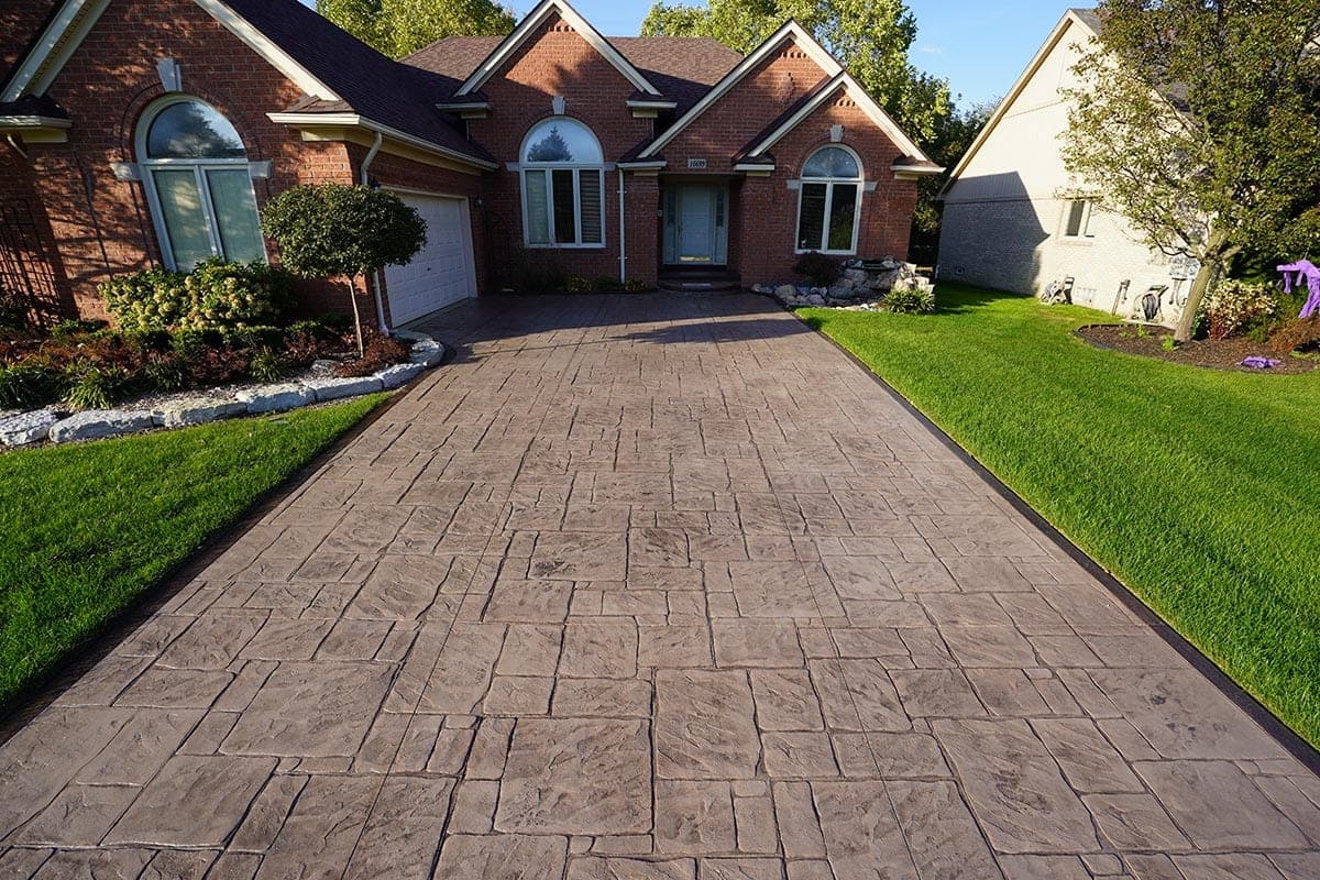 TriCity Concrete Sealing technician measuring a driveway during a free site assessment before providing a quote