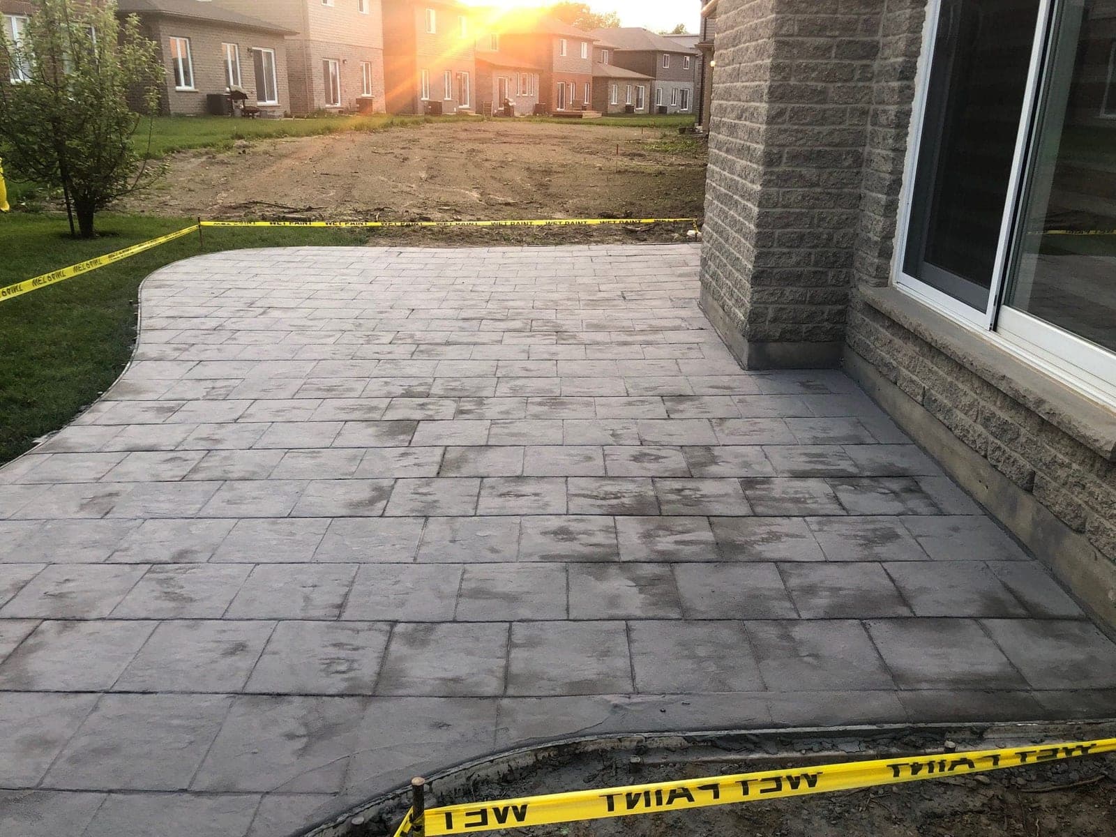 Sealed stamped concrete patio at sunset behind a brick home in Southwestern Ontario