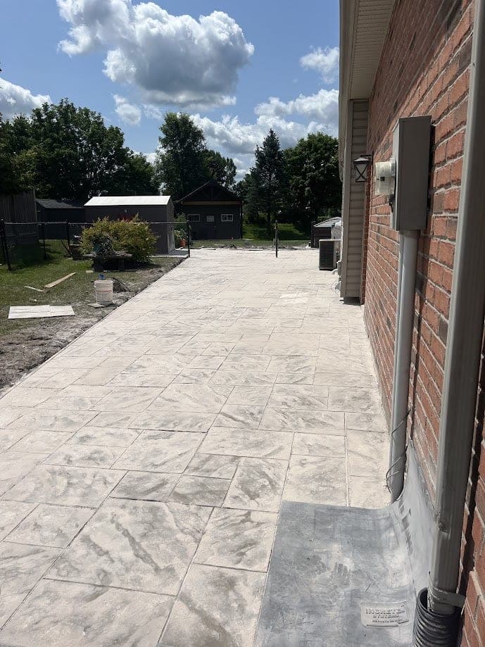 Stamped concrete patio sealed beside a brick home