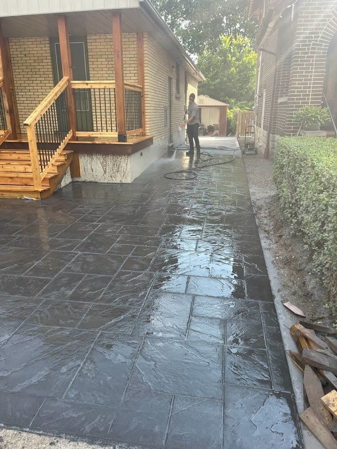 Stamped concrete patio under a deck with a sealed finish